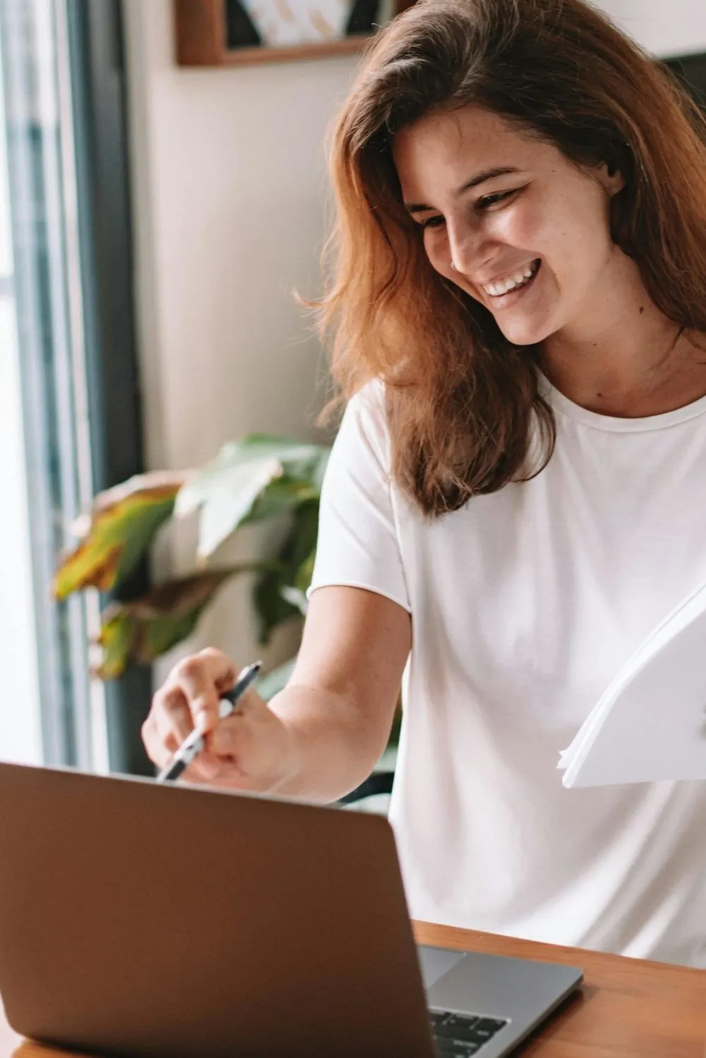 Lächelnde junge Frau arbeitet am Laptop