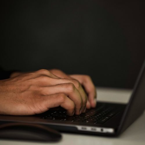 Hände tippen auf einem Laptop